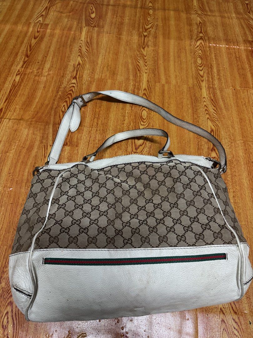 Gucci Monogram Canvas Leather Trim Shoulder Bag (Category: Bags & Wallets) located in Pasir Mas. Submitted by mannixbundle (Listing ID 1448635028, Image 1). Description: - Authentic Gucci shoulder bag - Classic GG monogram canvas - White leather trim - Signature green and red stripe detail - Silver hardware with Gucci engraving - Interior zipper pocket - Minor signs of wear on leather and straps - Perfect for everyday use.