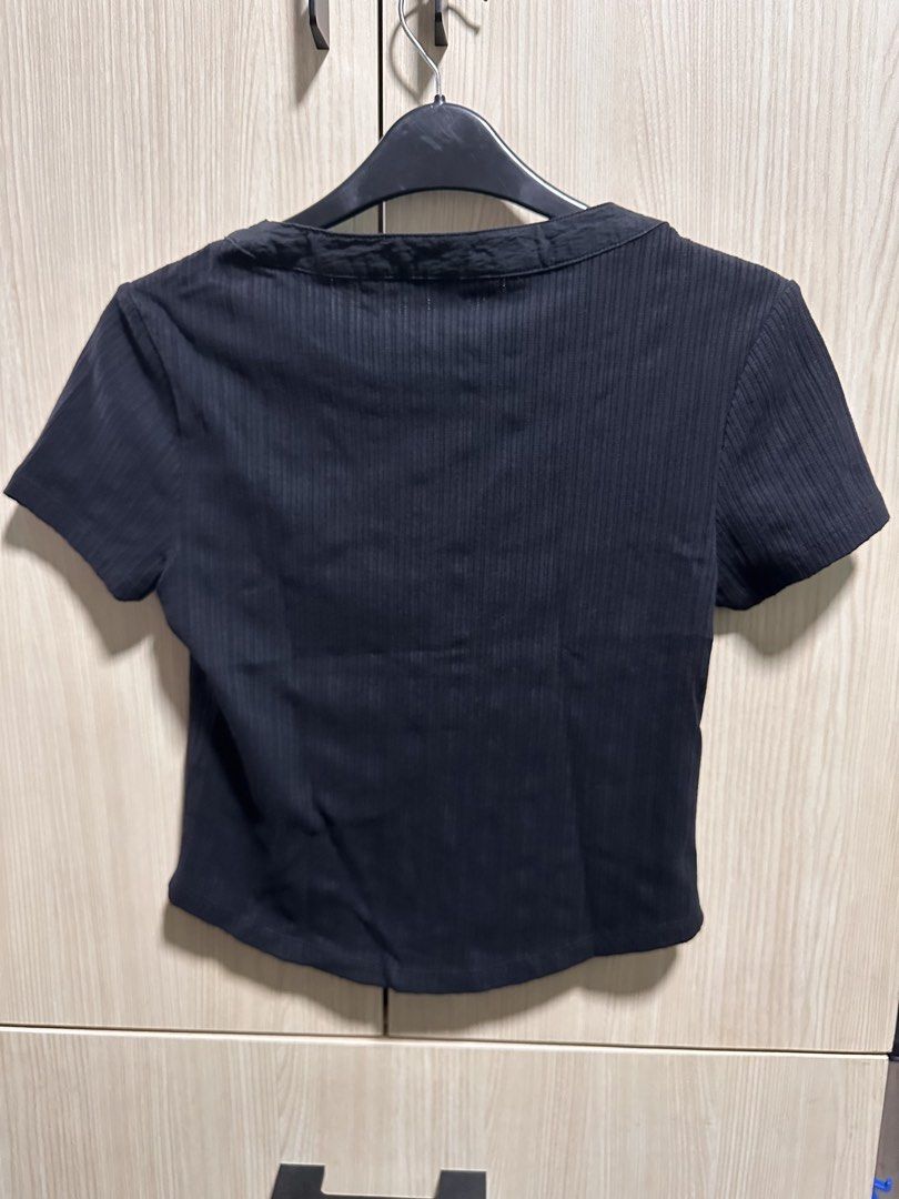 H&M Black Ribbed Cropped Henley Top (Category: Shirts) located in Makati City. Submitted by rmgcloset (Listing ID 1448491718, Image 3). Description: - Black H&M cropped top - Ribbed material - Short sleeves - Henley neckline with button details - Estimated size: S - Ideal for casual wear.