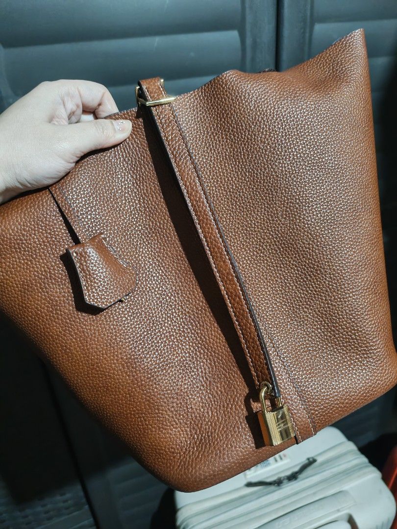 Imported Brown Leather Bucket Tote Bag with Lock (Category: Tote Bags) located in Caloocan City. Submitted by mommyella22 (Listing ID 1448621677, Image 2). Description: - Classic brown leather bucket bag - Pebbled leather texture - Includes small padlock and key - Comfortable top handles Super Gandaaa - Simple and chic design - Ideal for everyday wear BKK bought🇹🇭.