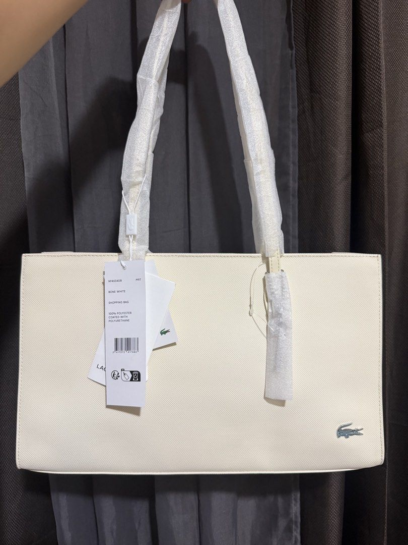 Lacoste Bone White Shopping Bag Tote (Category: Tote Bags) located in Manila. Submitted by rubyjaneba27331 (Listing ID 1448629898, Image 1). Description: - Lacoste shopping bag - Color: Bone white - Material: 100% Polyester with Polyurethane - Bought for 9k plus.