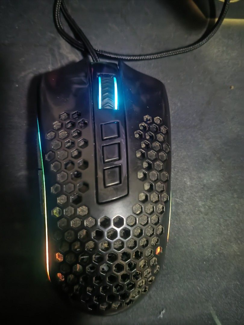 M808 STORM REDRAGON MOUSE (Category: Mouse & Mousepads) located in Angeles City. Submitted by ronaldfavored (Listing ID 1448623580, Image 1). Description: - Black gaming mouse with unique honeycomb design - Features vibrant RGB lighting effects - Wired USB connection for reliable performance - Works well, perfect for your gaming needs - Minor dust from normal use, doesn't affect functionality.