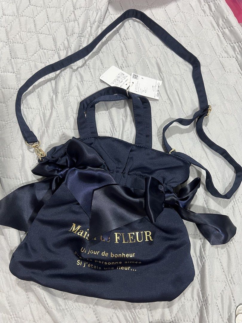 Maison de Fleur Satin 2-way bag (Category: Luxury Bags & Wallets) located in Makati City. Submitted by oldiesbutgoodiesbyg (Listing ID 1448618312, Image 3). Description: Brand new japan store bought. Maison de FLEUR is a highly popular Japanese brand celebrated for its feminine, romantic, and “coquette” aesthetic. Their iconic tote bags are easily recognized by their signature oversized satin side bows, ruffle handles, elegant gold-foil lettering