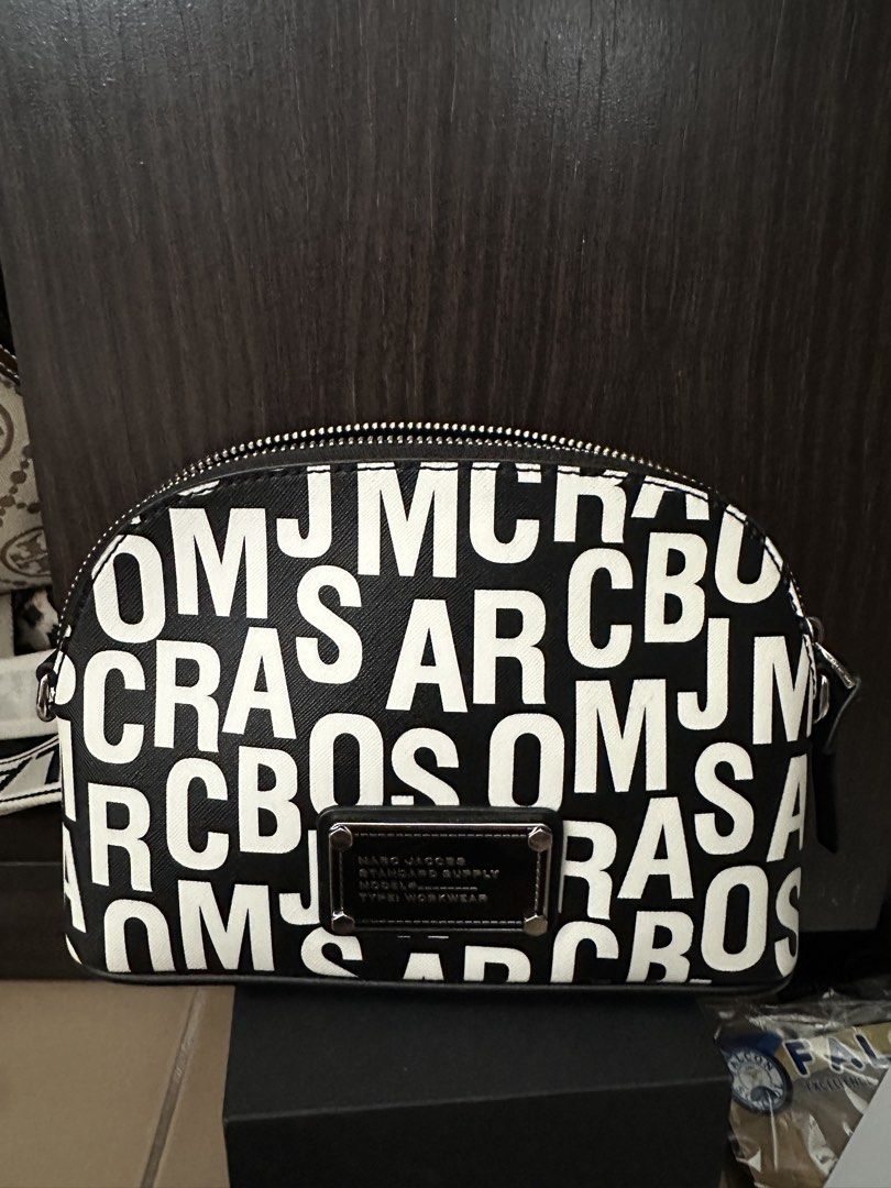 Marc Jacobs Dome (Category: Luxury Bags & Wallets) located in Manila. Submitted by maryjoremf13085 (Listing ID 1448511801, Image 1). Description: - Authentic Marc Jacobs cosmetic bag - Classic black and white all-over logo print - Secure zipper closure - Interior features a convenient slip pocket - Detachable strap included - Ideal for organizing makeup and essentials for travel or everyday.