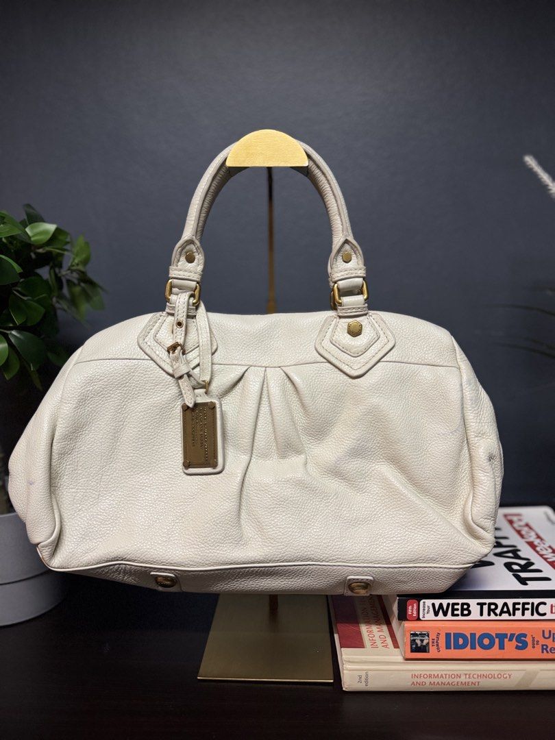 Marc Jacobs White Leather Satchel Handbag (Category: Luxury Bags & Wallets) located in Makati City. Submitted by bagattic_etc (Listing ID 1448485512, Image 1). Description: Perfect for work, casual outings, or semi-formal occasions. ✔ Authentic Marc Jacobs ✔ Soft genuine leather ✔ Spacious interior – fits daily essentials ✔ Classic neutral color – easy to match ✔ Gold hardware accents ✔ In good pre-owned condition (light signs of use only) 📌 Col