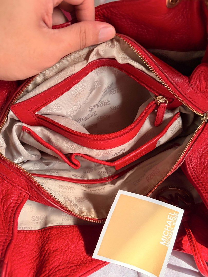 Michael Kors Red Leather Handbag (Category: Luxury Bags & Wallets) located in Rizal. Submitted by bingbong21 (Listing ID 1437347736, Image 3). Description: - Red leather handbag - Gold-tone hardware - Top handle - Zip closure - Multiple compartments - MK logo charm - Textured leather exterior - Structured shape - Shoulder strap - Side pocket -shipping via JNT/lbc/lalamove.