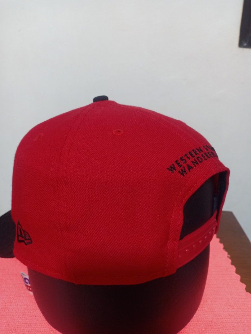 New Era Western Wanderers Red Black Snapback Cap (Category: Caps & Hats) located in Santa Rosa. Submitted by abj_104 (Listing ID 1448584860, Image 2). Description: - Western Wanderers snapback cap - Red crown with black brim - White embroidered Western Wanderers logo on front - New Era logo on the side - 'Western Wanderers' text embroidered on the back.