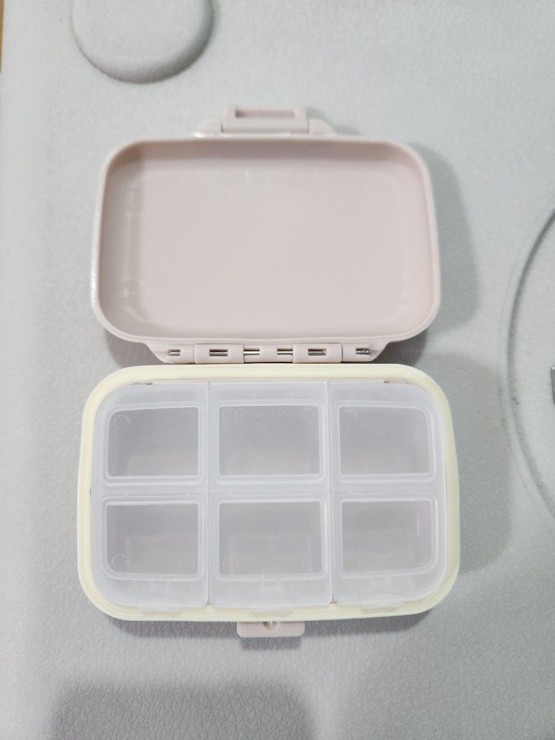 Portable and Detachable 6 Compartment Pill Organizer Case (Category: Accessory Holder, Box & Organizers) located in San Juan City. Submitted by djdlm (Listing ID 1448632764, Image 1). Description: - Brand new and never used compact and detachable pill box with 6 individual compartments - Secure snap-shut lid; 1 cover for 2 slots - Removable inner tray - Light pink/pastel color, side border slightly yellow in color - Ideal for daily vitamins, medi