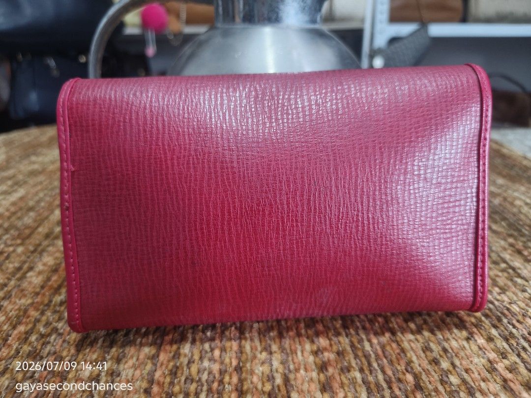PREMIERE TED LAPIDUS PARIS CLUTCH (Category: Luxury Bags & Wallets) located in Kalibo. Submitted by secondchances.thriftsh8p (Listing ID 1448556118, Image 2). Description: - PREMIERE clutch wallet in a beautiful red. - Textured leather finish for a sophisticated look. - Secure and easy-to-use metal clasp closure. - Ample space inside to carry all your essentials. - Versatile: Ideal for evening events or daily use. - Condition: Clean and well-main