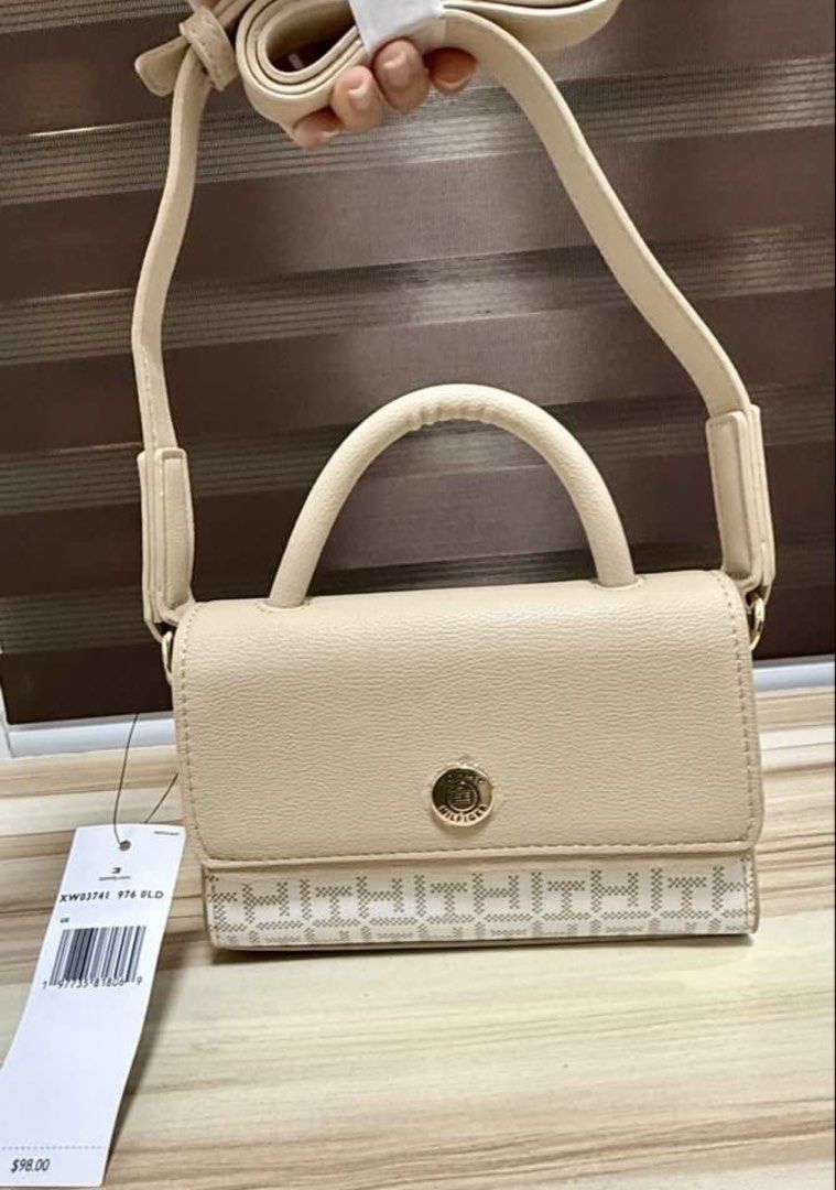 Tommy Hilfiger Beige Mini Top Handle Sling Bag (Category: Cross-body Bags) located in Mandaluyong City. Submitted by shoppingmilesph (Listing ID 1448619023, Image 2). Description: - Cute beige Tommy Hilfiger mini bag - Classic TH monogram pattern on bottom - Top handle and detachable shoulder strap included - Secure button clasp closure - Original retail price: $98.00 - Ideal for carrying your daily essentials.