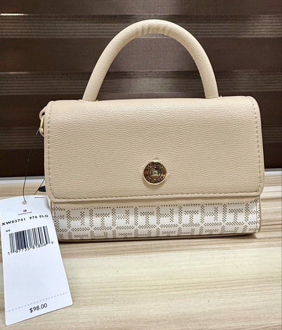 Tommy Hilfiger Beige Mini Top Handle Sling Bag (Category: Cross-body Bags) located in Mandaluyong City. Submitted by shoppingmilesph (Listing ID 1448619023, Image 1). Description: - Cute beige Tommy Hilfiger mini bag - Classic TH monogram pattern on bottom - Top handle and detachable shoulder strap included - Secure button clasp closure - Original retail price: $98.00 - Ideal for carrying your daily essentials.