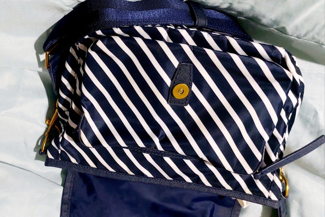 Tory Burch Striped Nylon Crossbody Bag (Category: Luxury Bags & Wallets) located in Cainta. Submitted by veronica2277 (Listing ID 1448531947, Image 3). Description: Almost new original navy white striped Tory Burch shoulder/body bag. Very nice and light. - Durable nylon material with leather trim - Main compartment with interior zip pocket - Front flap closure with secure snap button - Adjustable strap for comfortable wear - Elegant gold hardware