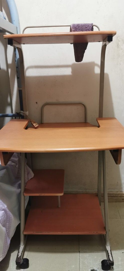Wooden Computer Desk with Shelves and Wheels (Category: Tables & Sets) located in Bacoor. Submitted by prelovedbylixic (Listing ID 1448693577, Image 1). Description: rfs: decluttering flaws: check photos, no pull-out keyboard tray, needs cleaning Compact wooden computer desk without pull-out keyboard tray and two shelves. Sturdy metal frame with wheels. .