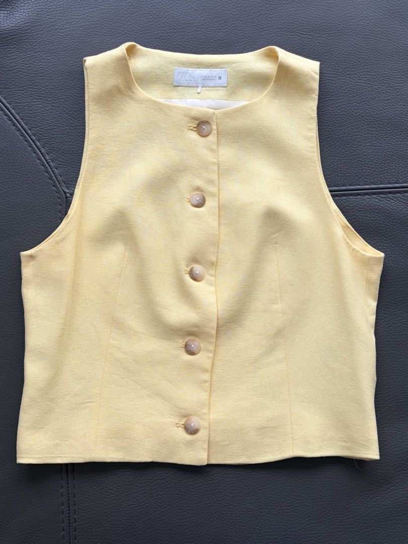 ZARA Yellow Sleeveless Button-Up Vest Top （分類：背心）位於 Hong Kong。 由 Luxvibes 提交（商品編號 1448591089，圖片 1）。簡介： Yellow vest from ZARA. Sleeveless design with button-up front. Made in Morocco. Size XS. Looks great layered over a t-shirt or worn on its own. Simple and classic style.。