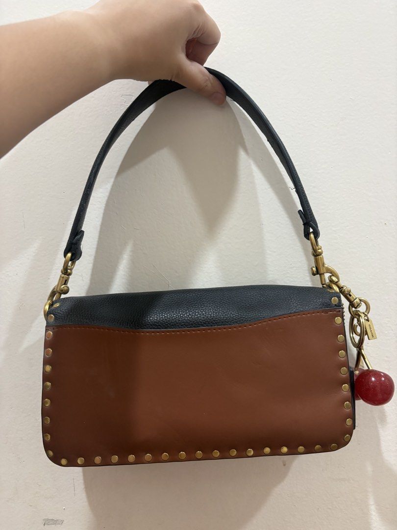 Coach Tabby Shoulder Bag with Cherry Charm (Category: Luxury Bags & Wallets) located in Manila. Submitted by alyannaros79007 (Listing ID 1453153801, Image 2). Description: - Coach Tabby shoulder bag - Color: Black and brown leather - Details: Gold stud accents - Charm: Cute cherry charm included - Interior: Lined with a zip pocket - Hardware: Gold-tone - Strap: Adjustable - Ideal for: Everyday use.