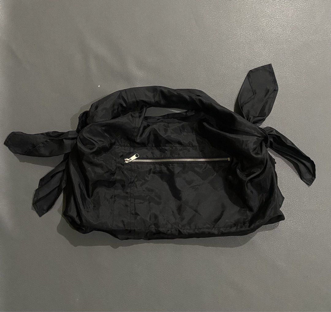 Comme des Garçons shoulder Bag (Category: Luxury Bags & Wallets) located in Pozorrubio. Submitted by izaykite2g (Listing ID 1453204191, Image 1). Description: - Authentic Comme des Garçons black nylon bag - Features a convenient zippered pocket on the front - Unique straps that tie into bows on the sides - Versatile styling options: can be tied in various ways.