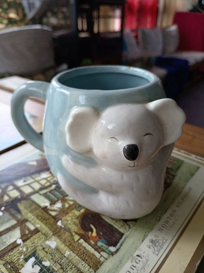 Cute Koala Hugging Mug (Category: Coffee & Tea Tableware) located in Makati City. Submitted by meowmyella (Listing ID 1453061907, Image 1). Description: - Adorable light blue mug featuring a koala hugging the side. - Perfect for your morning coffee or tea. - Microwave safe for convenient heating. - Please note: Hand wash recommended (not dishwasher safe). - A charming addition to your kitchenware collection. - with chips on the lip Kindly send DM