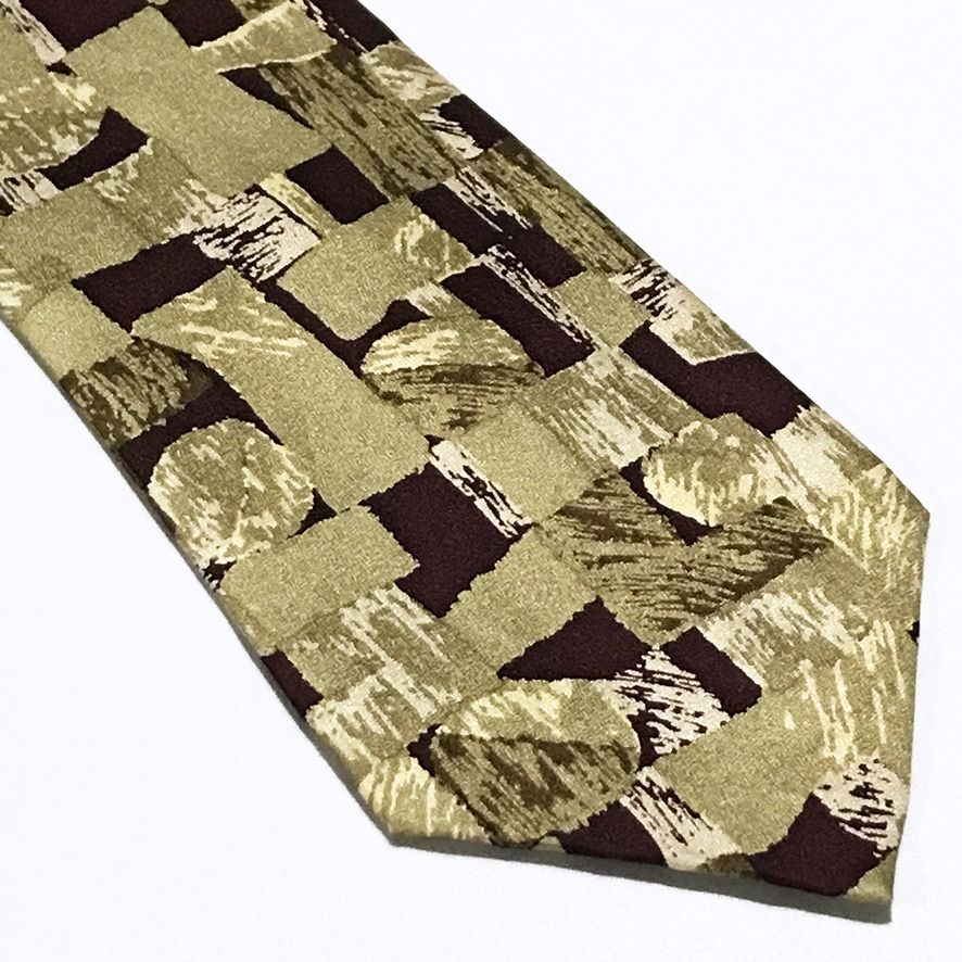 Emile Trahan Vintage Abstract Pattern Hand Made Neck Tie (Category: Ties) located in Taguig. Submitted by retrogaze (Listing ID 1453182308, Image 2). Description: This artistic vintage handmade necktie by Emile Trahan is crafted from 100% silk featuring a subtle, refined texture throughout. Set against a muted khaki and olive background, the design showcases a bold abstract mosaic pattern composed of geometric block shapes and expressive, brushst