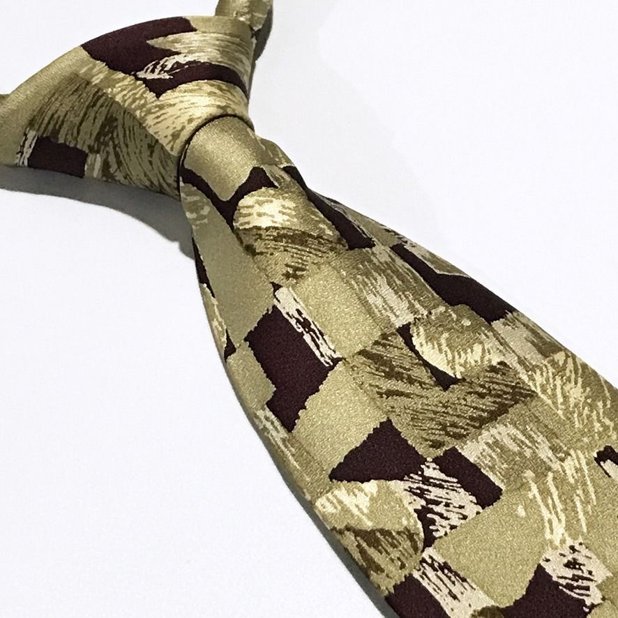 Emile Trahan Vintage Abstract Pattern Hand Made Neck Tie (Category: Ties) located in Taguig. Submitted by retrogaze (Listing ID 1453182308, Image 3). Description: This artistic vintage handmade necktie by Emile Trahan is crafted from 100% silk featuring a subtle, refined texture throughout. Set against a muted khaki and olive background, the design showcases a bold abstract mosaic pattern composed of geometric block shapes and expressive, brushst