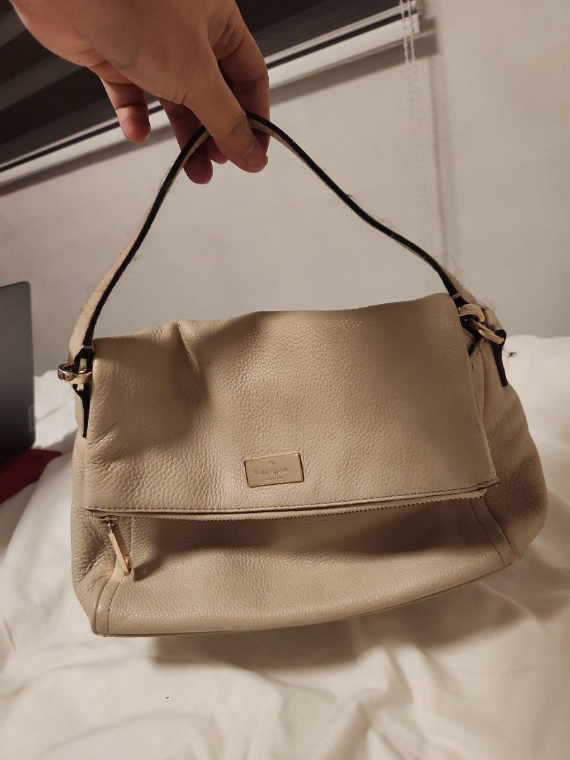 Kate Spade Beige Leather Handbag with Pink Interior (Category: Luxury Bags & Wallets) located in Valenzuela. Submitted by jochaaa011 (Listing ID 1453201269, Image 1). Description: - Brand: Kate Spade - Color: Beige exterior, bright pink interior with signature print - Material: Genuine Leather - Closure: Zipper - Condition: Exterior leather shows some wear, particularly on straps. Interior lining has marks and scuffs. - Style: Perfect for everyda
