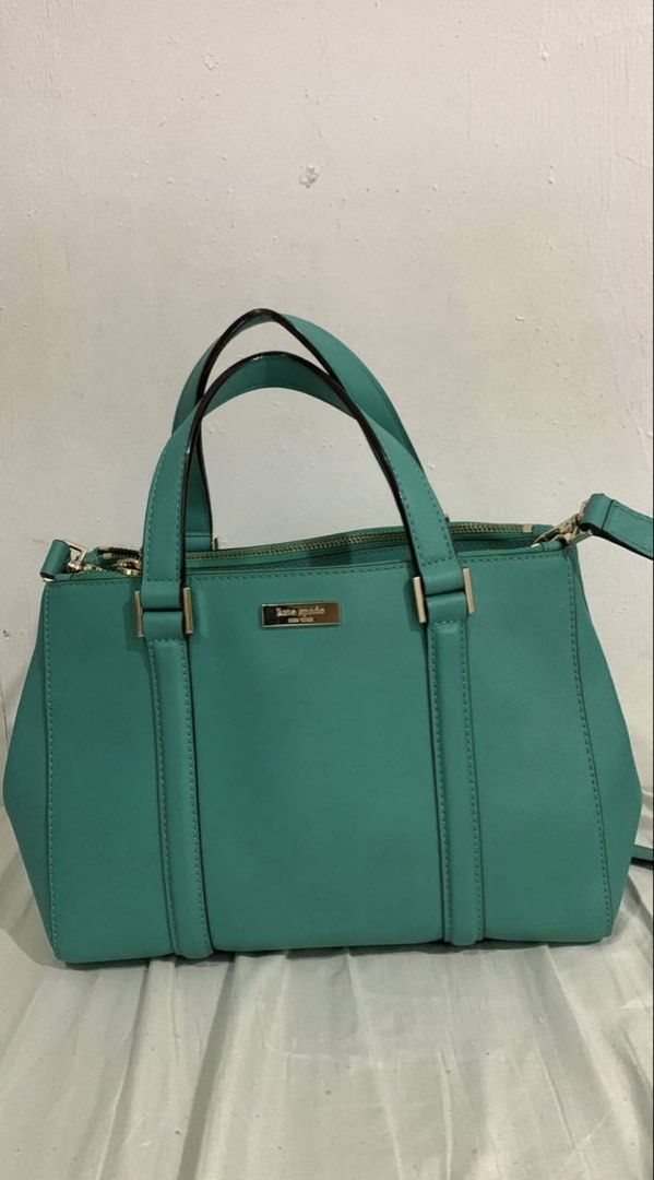 Kate Spade Teal Leather Satchel Handbag (Category: Clutches) located in Manila. Submitted by DECLUTTERWITHADA (Listing ID 1453146810, Image 1). Description: - Authentic Kate Spade teal leather satchel - Elegant gold hardware details - Versatile carrying options: top handles and detachable crossbody strap - Secure zipper closure - Interior features a stylish patterned lining - Ample space for all your essentials - Ideal for everyday wear and styli