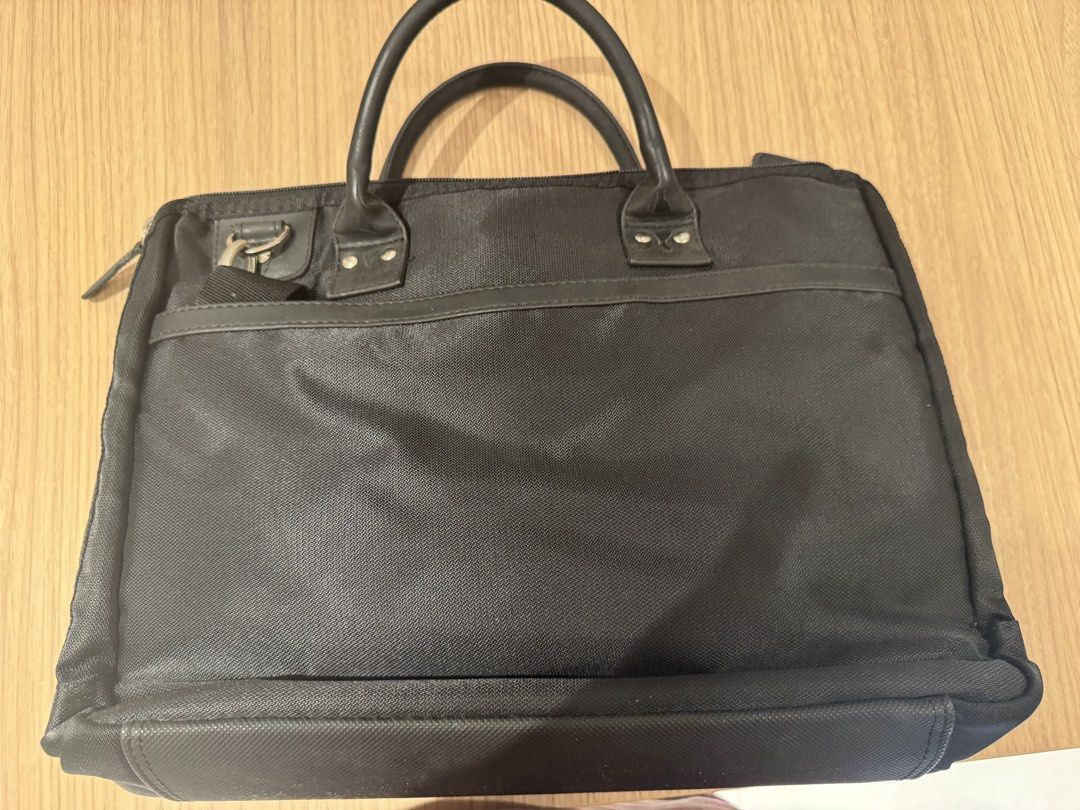 Laptop bag (Category: Briefcases) located in Quezon City. Submitted by tinylee60 (Listing ID 1453098288, Image 2). Description: - Durable black nylon construction - Elegant leather handles and trim - Convenient front zip pocket with metal logo plate - Spacious main compartment with internal organization pockets - Includes a detachable shoulder strap for versatile carrying - Ideal for professional use or travel Size 11” x 16” x3”depth .