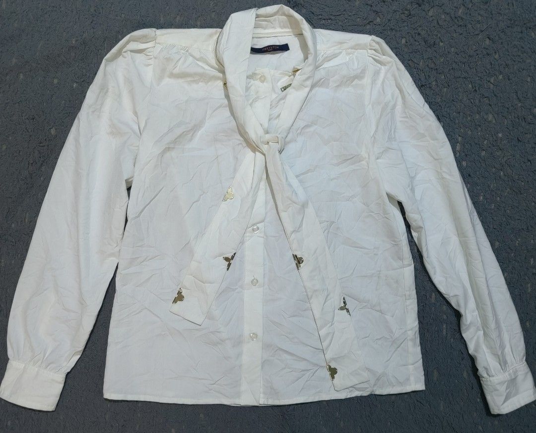 Louis Vuitton White Butterfly Embellished Bow Blouse (Category: Blouses) located in Las Pinas. Submitted by huslerz (Listing ID 1453093304, Image 1). Description: - Elegant white Louis Vuitton blouse - Features a stylish tie-neck detail - Adorned with small, charming butterfly embellishments - Long sleeves with classic buttoned cuffs - Chic gold zipper detail on the collar 20x26 dimes.