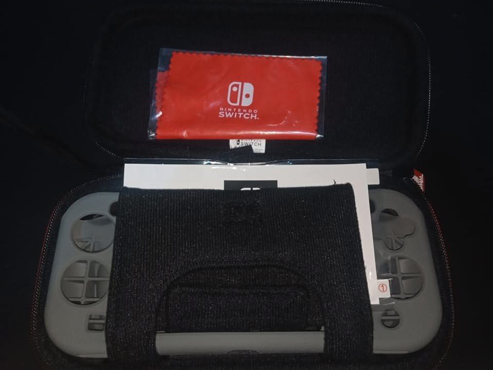 Nintendo Switch Lite Carrying Case with Screen Protector (Category: Nintendo) located in Cavite. Submitted by mikeyyyy10 (Listing ID 1453213060, Image 3). Description: - Hard shell carrying case for Nintendo Switch Lite - Includes screen protector and cleaning cloth - Secure zippered closure with red Nintendo Switch zipper pull - Interior mesh pocket for accessories - Molded insert for secure console fit - Ideal for travel and device protection.