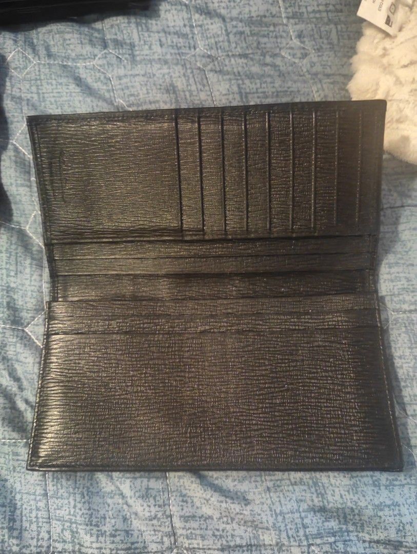 Original and Classic Ferragamo Bi-fold Wallet (Category: Luxury Bags & Wallets) located in Manila. Submitted by dcsago (Listing ID 1453235171, Image 2). Description: Salvatore Ferragamo Black Leather Long Wallet Classic and elegant Salvatore Ferragamo long wallet crafted from textured black leather. Features the iconic Gancini logo on the front with a subtle red accent line, giving it a timeless and sophisticated look. The slim design offers ampl