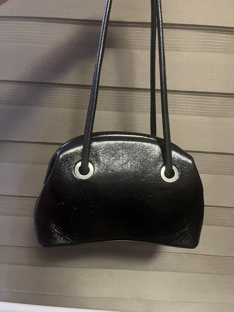 Osoi Black Patent Leather Shoulder Bag with Silver Hardware (Category: Shoulder Bags) located in Plaridel. Submitted by rarefindlux (Listing ID 1453128686, Image 2). Description: - Black patent leather shoulder bag - Shiny, glossy finish - Silver hardware details on the front - Classic, versatile shape - Thin, comfortable leather straps - Black fabric interior with a small pocket.