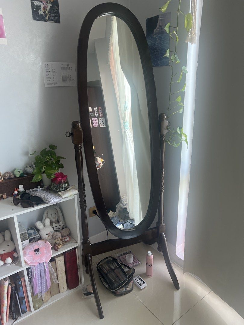 Oval Standing Mirror with Wooden Frame (Category: Mirrors) located in Taguig. Submitted by graceeeeeeeee (Listing ID 1453064168, Image 1). Description: - Full-length oval mirror - Dark wood frame with carved details - Sturdy base for freestanding use - Ideal for checking outfits - Adds a vintage aesthetic to any space - Clear, well-reflecting mirror.