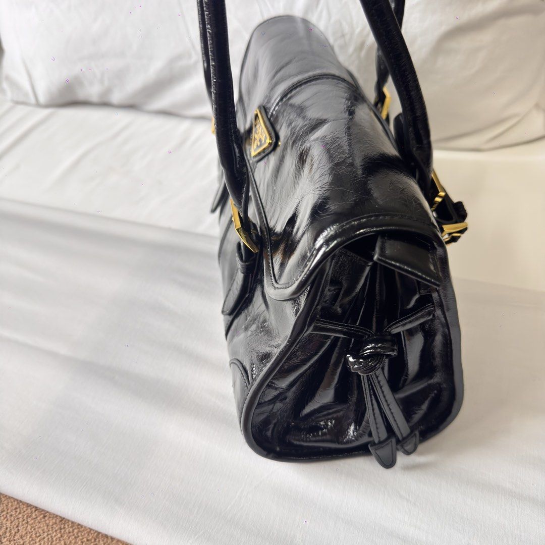 Prada Black Patent Leather Shoulder Bag (Category: Luxury Bags & Wallets) located in Mabalacat. Submitted by kay_miscak (Listing ID 1453114951, Image 2). Description: -Prada black patent leather shoulder bag - Elegant gold hardware details - Comfortable top handles - Secure buckle closures on the front - Lampo under zip -with black and white Prada tag - Spotless and clean interior - A truly classic and versatile piece for any wardrobe.