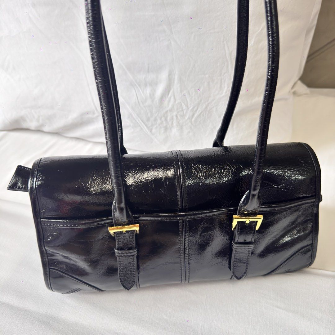 Prada Black Patent Leather Shoulder Bag (Category: Luxury Bags & Wallets) located in Mabalacat. Submitted by kay_miscak (Listing ID 1453114951, Image 3). Description: -Prada black patent leather shoulder bag - Elegant gold hardware details - Comfortable top handles - Secure buckle closures on the front - Lampo under zip -with black and white Prada tag - Spotless and clean interior - A truly classic and versatile piece for any wardrobe.