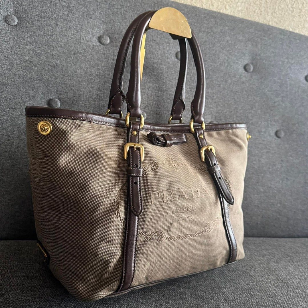 Prada Milano Canvas Leather Trim Tote Bag (Category: Luxury Bags & Wallets) located in Madrid. Submitted by jhunaceee (Listing ID 1453180428, Image 3). Description: - Authentic Prada tote bag - Color: Beige canvas with dark brown leather trim and handles - Hardware: Gold - Features: Embossed Prada Milano logo on front - Interior: Spacious, ideal for essentials - Perfect for: Everyday use.