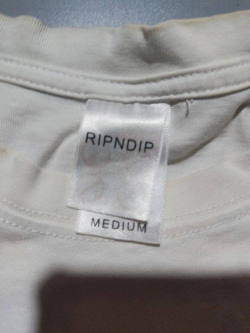 RIPNDIP White Pocket T-Shirt (Category: Activewear) located in Pasig City. Submitted by tobyrama (Listing ID 1453222226, Image 3). Description: RIPNDIP White Pocket T-Shirt ✔️ Condition: Preloved/so manage your expectations on this one po (it has stains banda neck collar) ✔️ Size: Medium (on tag) length: 25 inches width: 18 inches Can do J&T or Lalamove for same day shipping Can do meetup around, Market Market, Eastwood, SM Megamall, Tiendesitas 