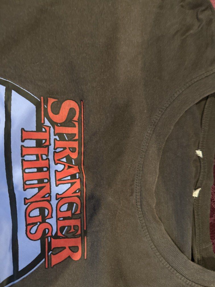 Stranger Things Graphic T-Shirt Croptop (Category: Shirts) located in Manila. Submitted by declutterthisandthat (Listing ID 1453116765, Image 2). Description: - Iconic Stranger Things logo with character silhouettes on bikes - Classic crew neck, short sleeves - Comfortable cotton blend fabric - Ideal for any fan of the hit show.