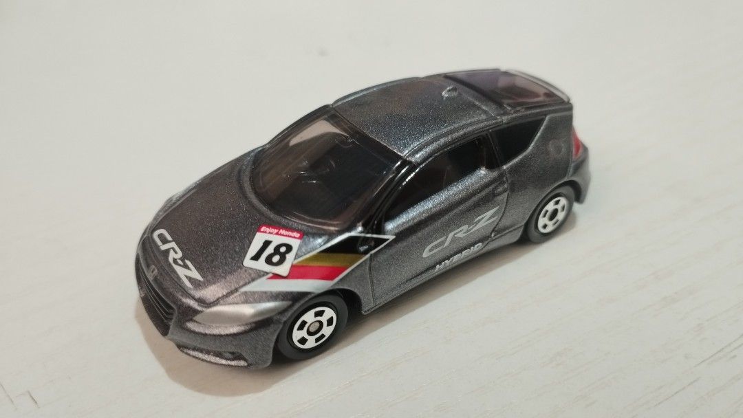 Tomica Honda CR-Z set (Category: Vehicle & Diecast Models) located in Santa Cruz. Submitted by .rx-78-2 (Listing ID 1453112365, Image 2). Description: - Two (2) Tomica Honda CR-Z hybrid diecast cars - Color 1: Metallic Orange - Color 2: Dark Grey with racing decals and number 18 - Highly detailed models - Ideal for collectors and display purposes.