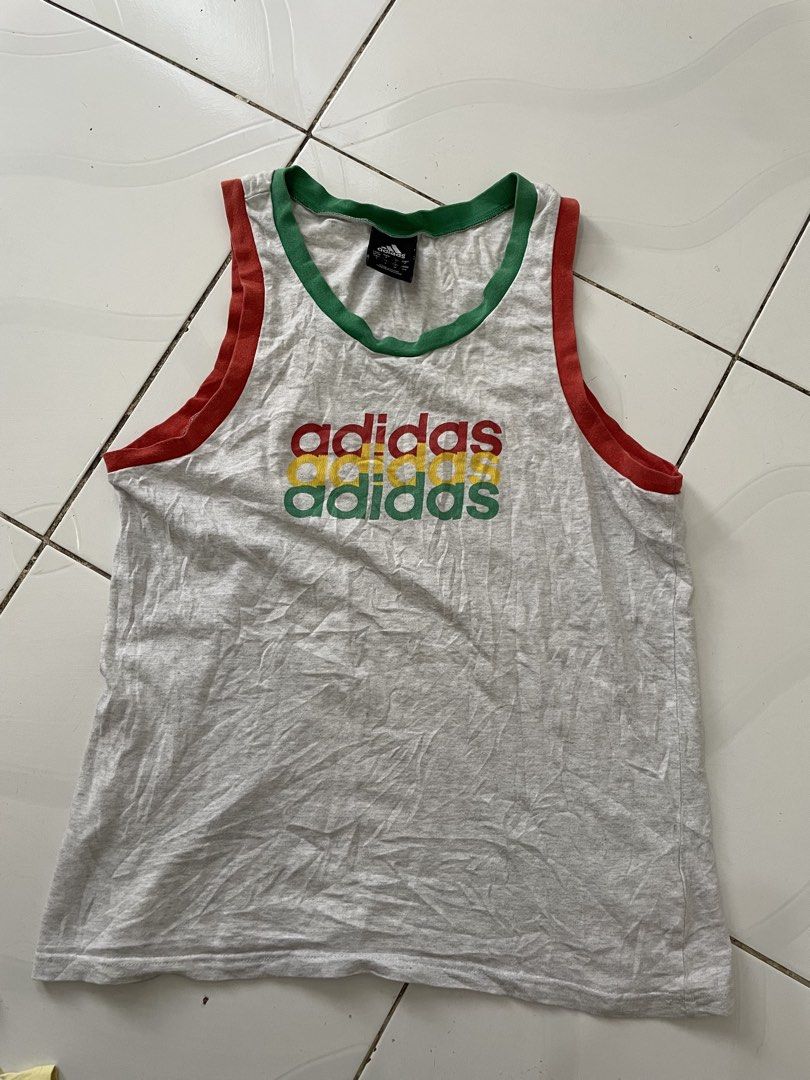 Vintage Adidas Grey Ringer Tank Top (Category: Sleeveless) located in Siniloan. Submitted by rethr1ft (Listing ID 1453064003, Image 1). Description: - Grey Adidas tank top - Ringer trim detail - Features iconic Adidas logo in red, yellow, and green - Size: S - Made in China - Ideal for casual wear or workouts.