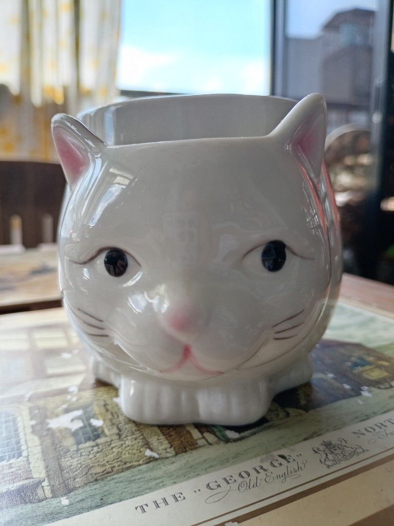 White Ceramic Cat Mug with Handle (Category: Coffee & Tea Tableware) located in Makati City. Submitted by meowmyella (Listing ID 1453060167, Image 1). Description: - Adorable white ceramic mug shaped like a cat. - Features a convenient side handle. - Ideal for your morning coffee or tea. - A fun and charming gift for any cat lover. Kindly send DM for more details.