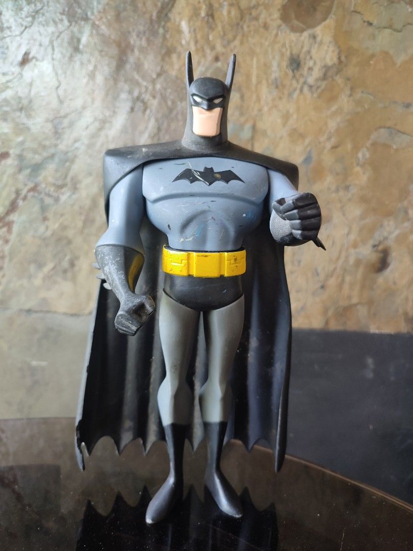 Batman 13" Figure (Category: Figurines & Statues) located in Manila. Submitted by paolobalan91142 (Listing ID 1454950573, Image 1). Description: - Classic Batman action figure from the animated series - Features the iconic grey and blue suit with a yellow belt - Black, textured cape - Fully articulated arms and legs for posing - Shows some minor paint wear on the chest and arms - A must-have for any Batman fan's collection.