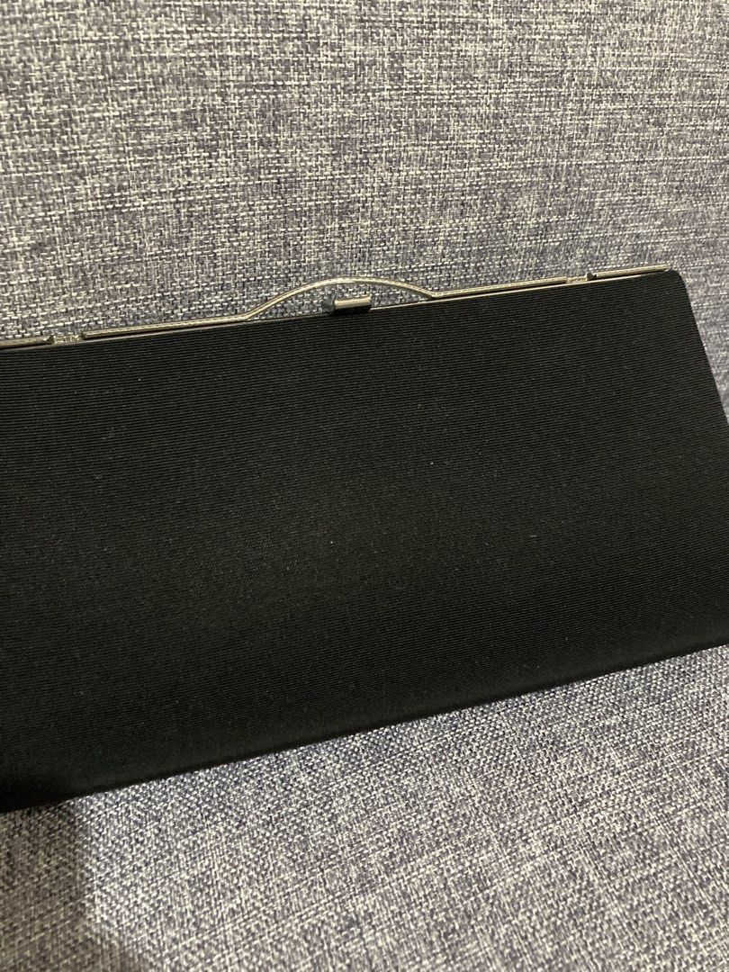 Black Fabric Clutch Bag with Silver Clasp (Category: Clutches) located in Valenzuela. Submitted by theaveqc04360 (Listing ID 1454905055, Image 2). Description: - Classic black clutch bag - Textured weave fabric exterior - Secure silver metal clasp closure - Interior includes a small chain strap - Built-in card slots for essentials - Perfect for evenings out or special occasions - Approximate dimensions: 9 inches wide, 4 inches tall.
