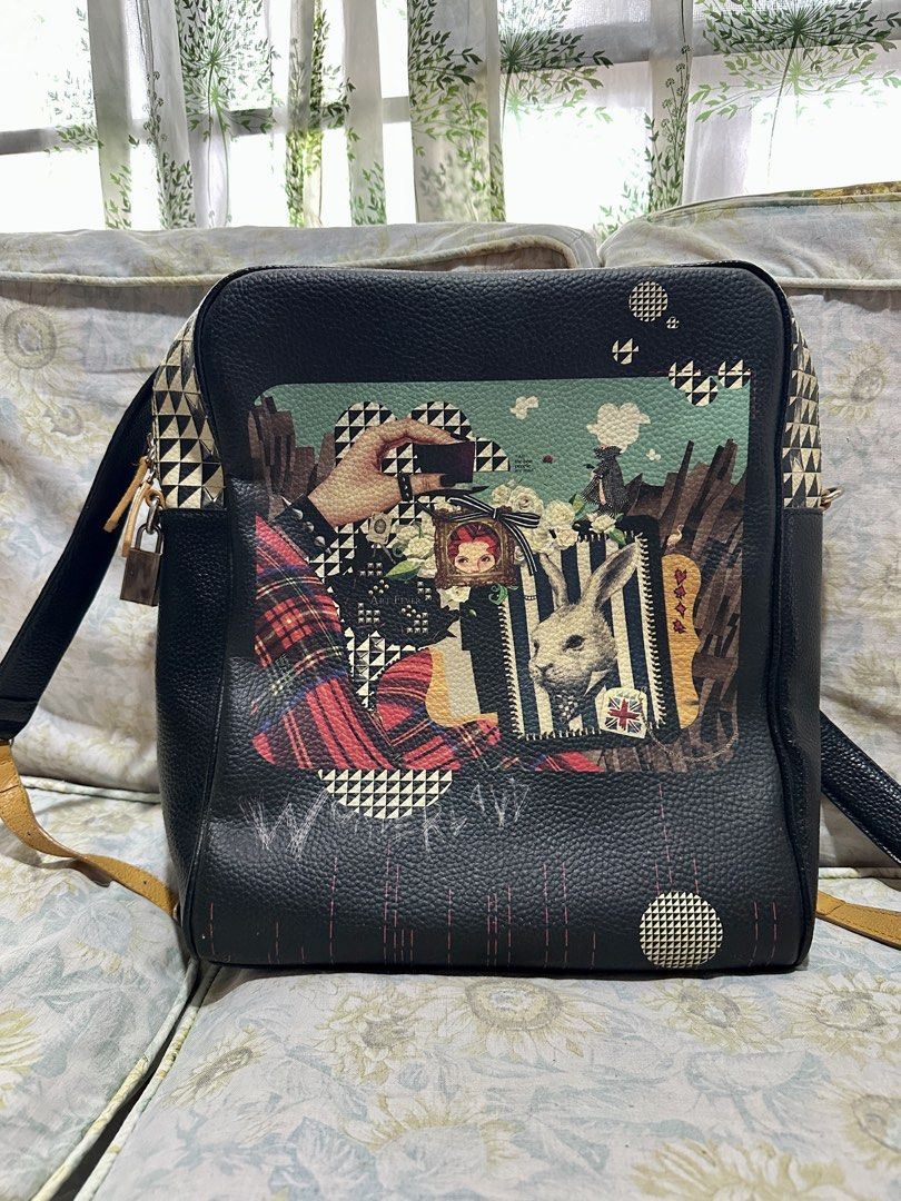 Brera Art Fever - Original Art Bag (Category: Backpacks) located in Binangonan. Submitted by joizeeful (Listing ID 1454758131, Image 2). Description: - Black Leather Backpack with Whimsical Graphic Print - Stylish black leather backpack - Unique artistic graphic print on front: features a rabbit, hand taking a photo, and plaid details - Multiple zippered pockets (front and back) for secure storage - Adjustable straps for a comfortable, customized