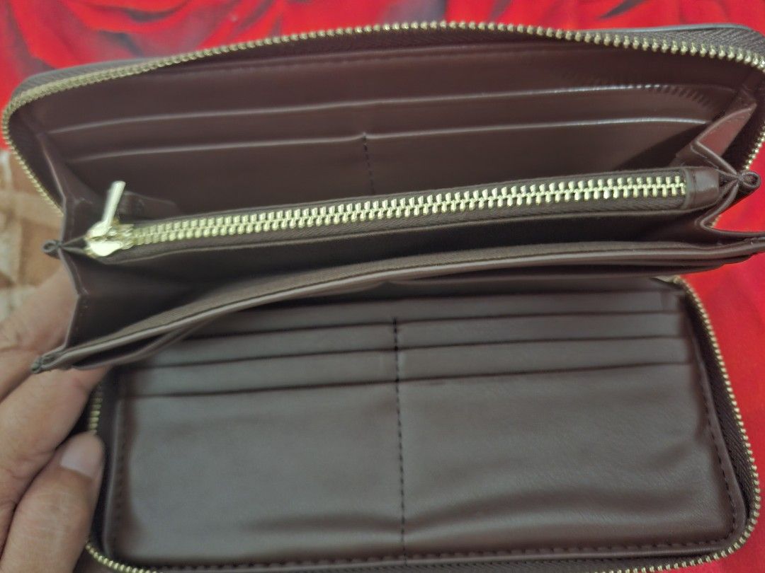 Brown Leather Zip Around Wallet with Gold Logo (Category: Wallets & Card holders) located in Muntinlupa City. Submitted by abunching (Listing ID 1454908312, Image 3). Description: - Rich brown leather wallet - Elegant gold zipper closure - Prominent gold logo on the front - Ample card slots for all your cards - Multiple compartments for bills and essentials - Includes a small zippered pocket for coins or small items - Perfect for keeping your cas