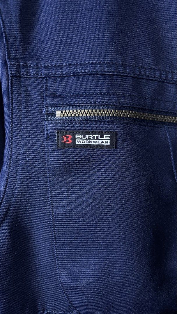 BURTLE WORKWEAR Navy Blue Jacket Size M (Category: Coats, Jackets and Outerwear) located in Bacoor. Submitted by calvinmanzano13 (Listing ID 1454785801, Image 3). Description: - L = 23.5” | W = 21.5” - Zip-up front closure - Multiple pockets, including a zippered chest pocket - Features Japanese text embroidery on front and sleeve - Elasticated cuffs and hem for a snug fit - Versatile for work or casual outfits Notes: ☑️ Brand new (removed tags b