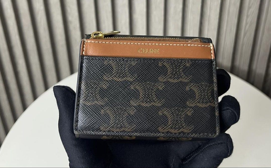 Celine Triomphe Canvas Small Wallet (Category: Luxury Bags & Wallets) located in Taguig. Submitted by almero22 (Listing ID 1454910886, Image 2). Description: - Authentic Celine small wallet - Iconic Triomphe canvas with Triomphe logo hardware - Practical design with a zip pocket and card slots - Elegant brown and black colorway.