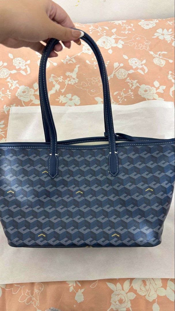 Christy Ng Navy Monogram Tote Bag with Pouch (Category: Tote Bags) located in Binan City. Submitted by franchescalavina (Listing ID 1454903072, Image 2). Description: - Navy blue Christy Ng tote bag (dupe) - Features signature monogram pattern - Comes with a matching smaller pouch inside - Interior is lined with canvas - Small mark inside the bag (shown in the last photo) - Great for everyday use.