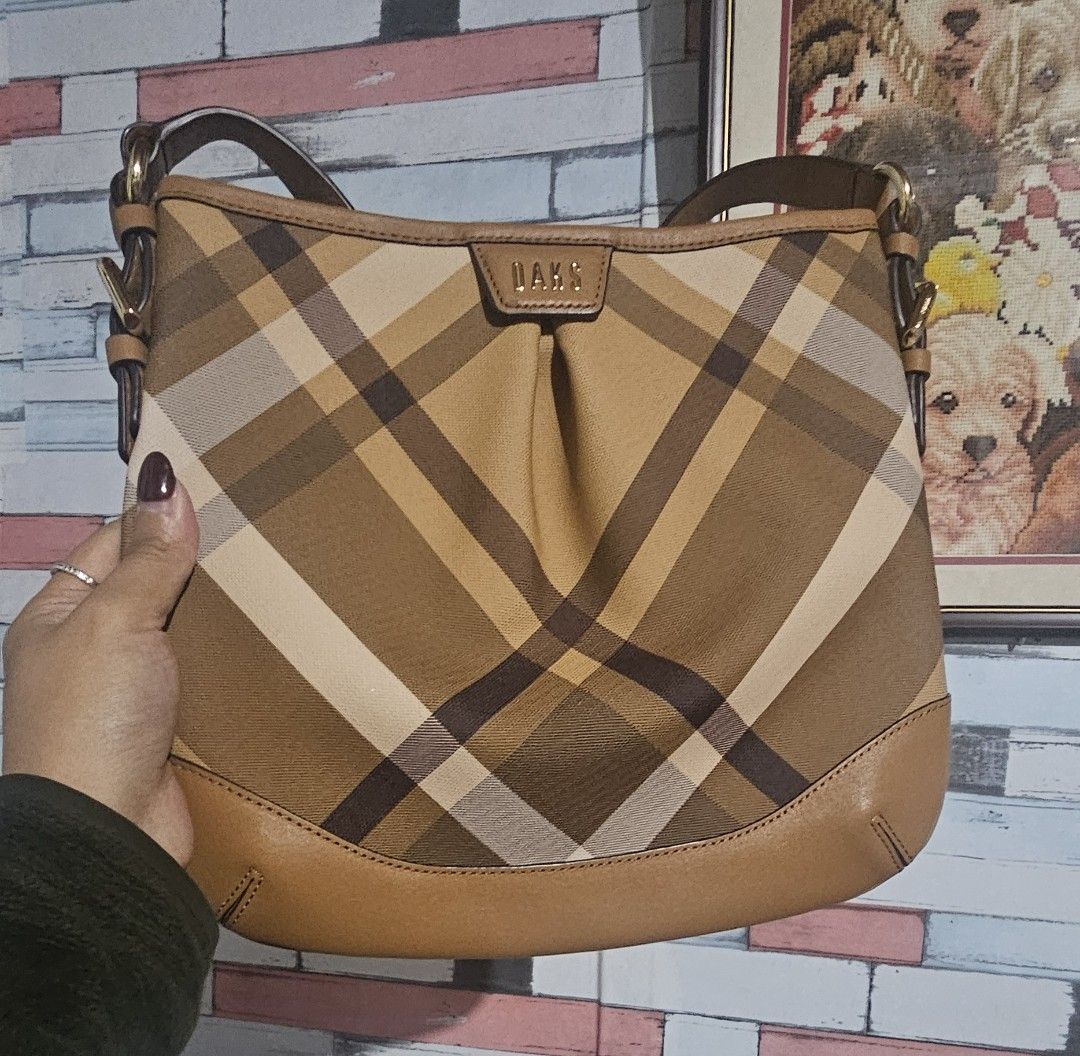 DAKS Plaid Shoulder Bag (Category: Shoulder Bags) located in Baguio. Submitted by msgold2601 (Listing ID 1454848452, Image 1). Description: - Classic DAKS plaid shoulder bag - Stylish tan and brown checkered pattern - Genuine leather trim - Adjustable strap for comfortable wear - Ideal size for everyday essentials -waterproof mga mima.