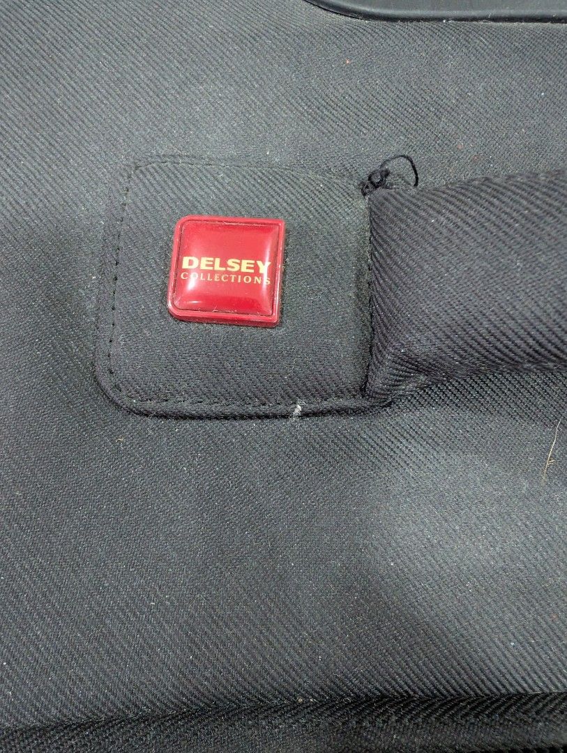 Delsey Collection Black Softside Spinner Luggage (Category: Luggage) located in Silang. Submitted by akalcol (Listing ID 1454842311, Image 2). Description: - Brand: Delsey - Color: Black - Exterior Features: Front zippered pocket - Interior Features: Burgundy fabric lining - Mobility: Four spinner wheels for 360° maneuverability - Handle: Extendable - Condition: Used, with some signs of wear on exterior and wheels .