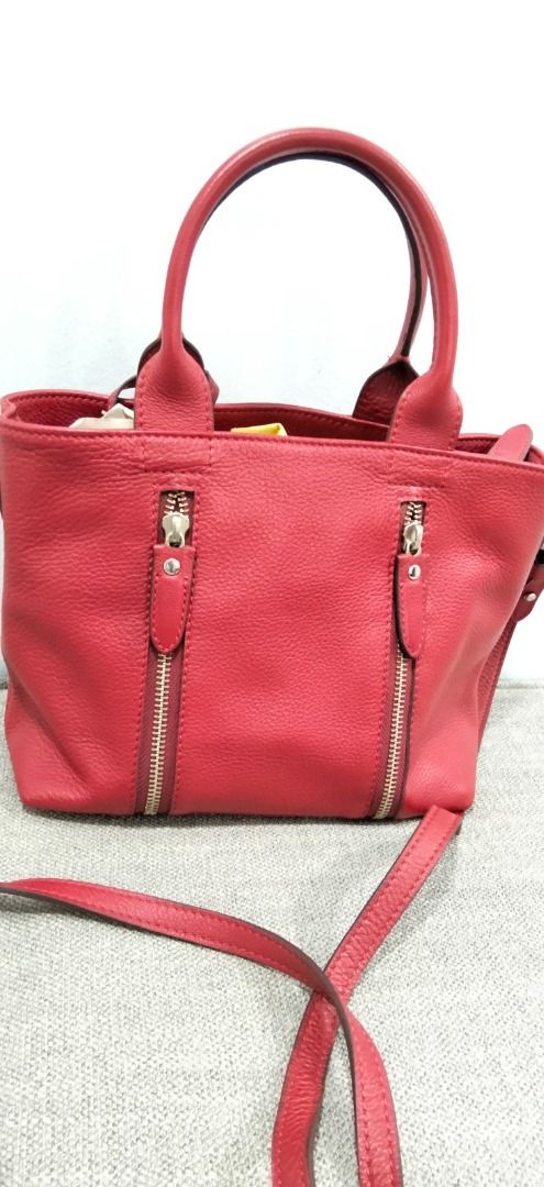 FINO Leatherware Red Pebble Grain Leather Handbag (Category: Luxury Bags & Wallets) located in Makati City. Submitted by pre_loved_items_.moon (Listing ID 1454816144, Image 3). Description: - Genuine red leather handbag from FINO Leatherware - Elegant pebble grain texture - Comfortable top handles - Includes a detachable crossbody strap for versatility - Two convenient zippered pockets on the front - Interior lined with red fabric - Ample space f