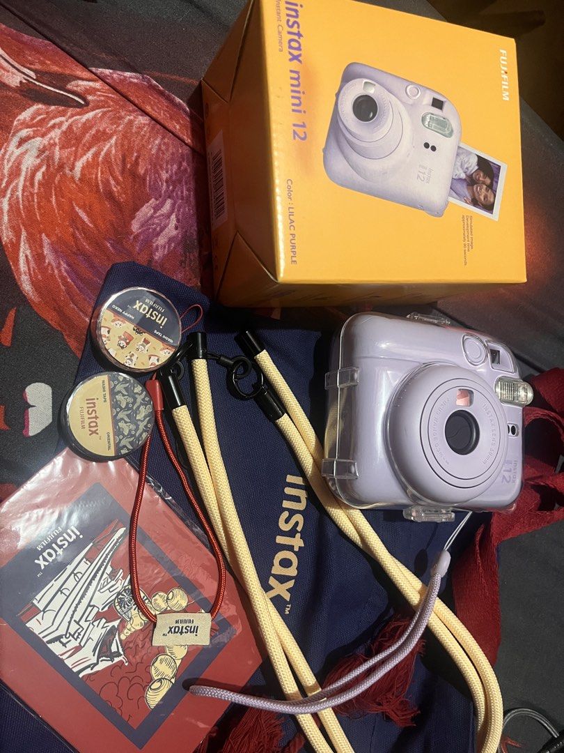 Fujifilm Instax Mini 12 Lilac Purple Camera Bundle (Category: Cameras) located in Manila. Submitted by drzy_28 (Listing ID 1454782926, Image 1). Description: Bought it brand new at original price last May and only used it at home so it comes w film pa since pang test shot lang ‘yung mga nabawas. Selling because | don’t use it anymore. Condition: Very well-kept Inclusions: - Fujifilm Instax Mini 12 Camera in Lilac Purple - Includes a clear protect