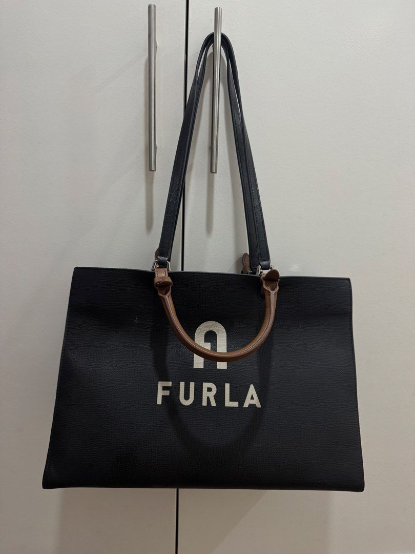 Original Furla Black Tote Bag with Logo (Category: Luxury Bags & Wallets) located in Muntinlupa City. Submitted by lrio.emlyrse (Listing ID 1454946166, Image 1). Description: - Original and genuine Furla tote bag - Features the iconic Furla logo printed on the front - Equipped with two comfortable top handles - Spacious interior, ideal for everyday use - Clean and minimalist design - Barely used RFS: No longer working in the office Purchased it P